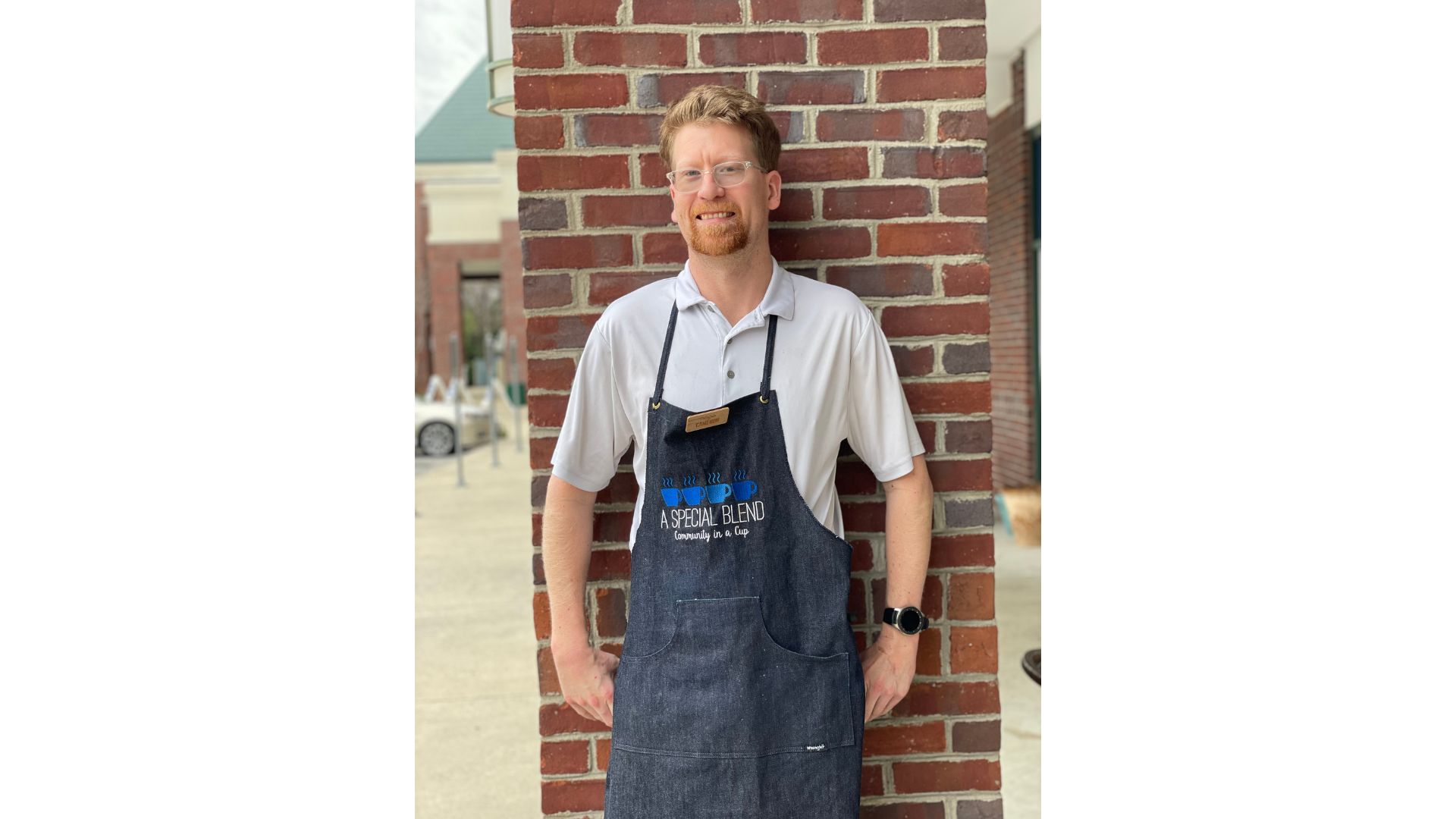 a man standing in front of a brick wall