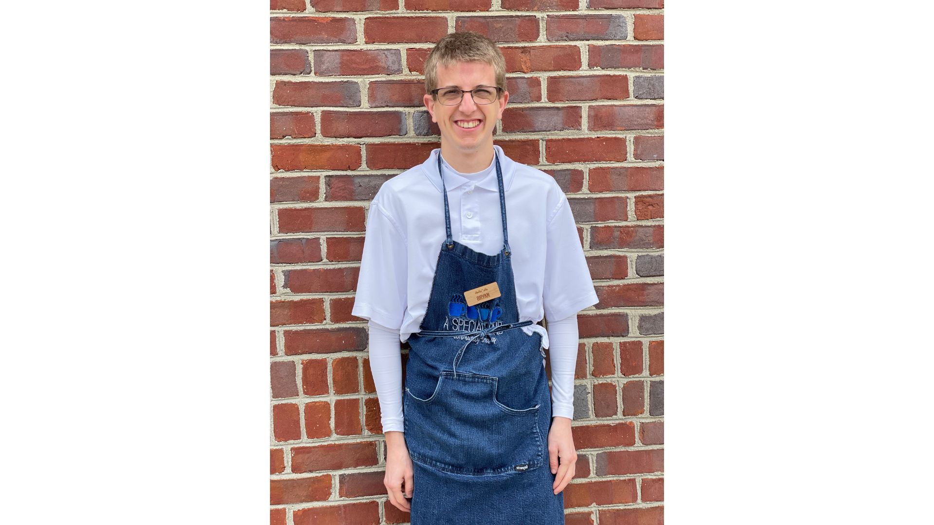 a man standing in front of a brick wall