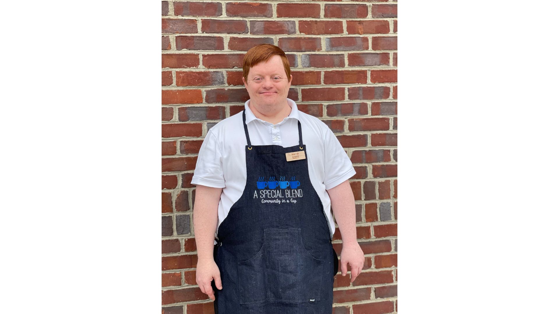 a man standing in front of a brick wall