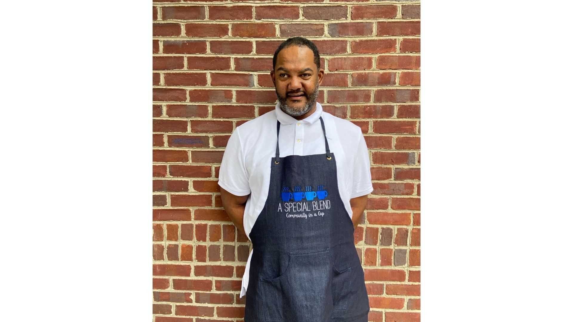 a man standing in front of a brick wall