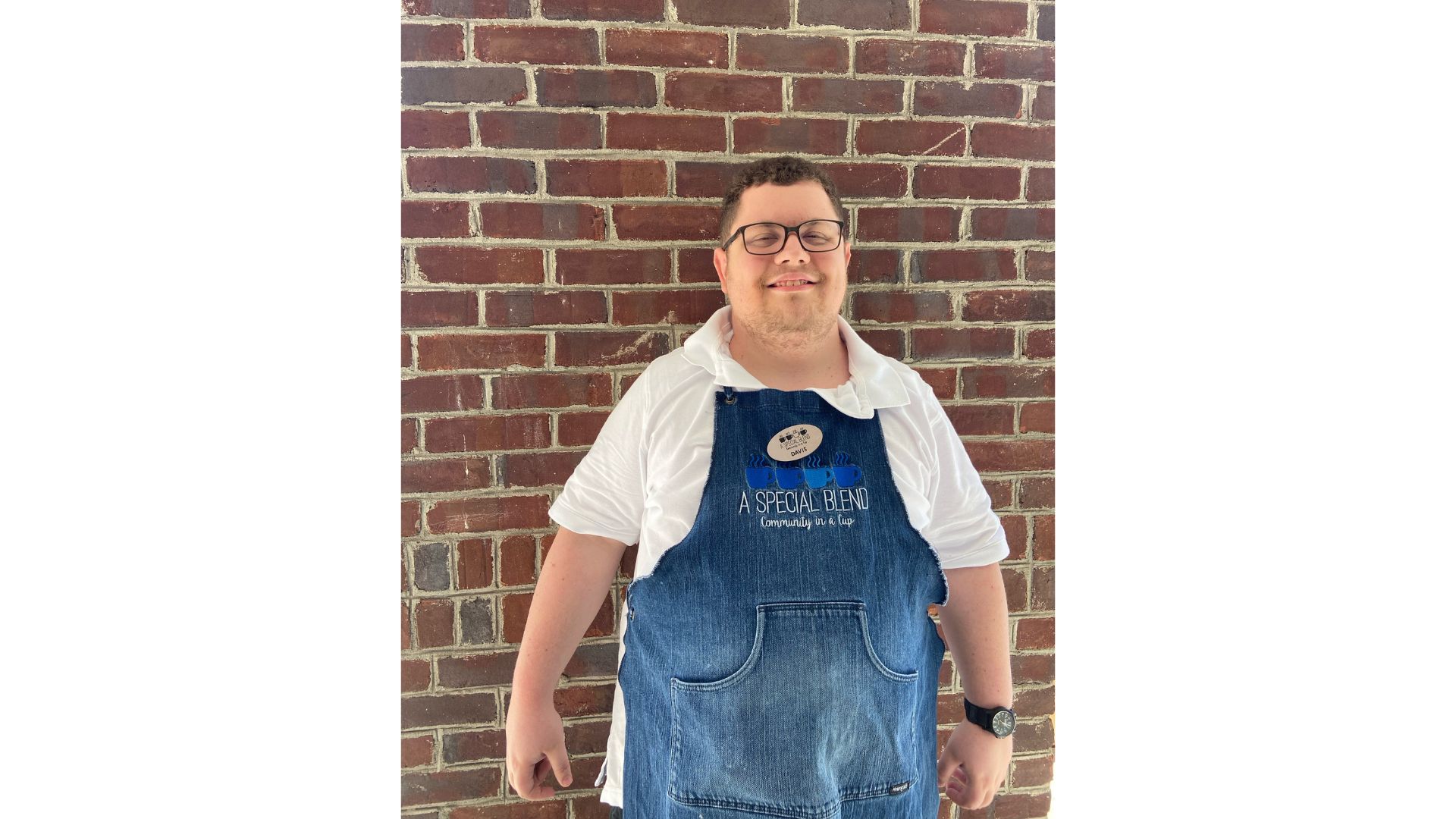 a man standing next to a brick wall
