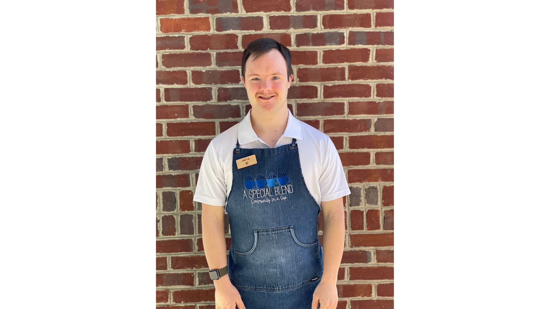 a man standing in front of a brick wall posing for the camera