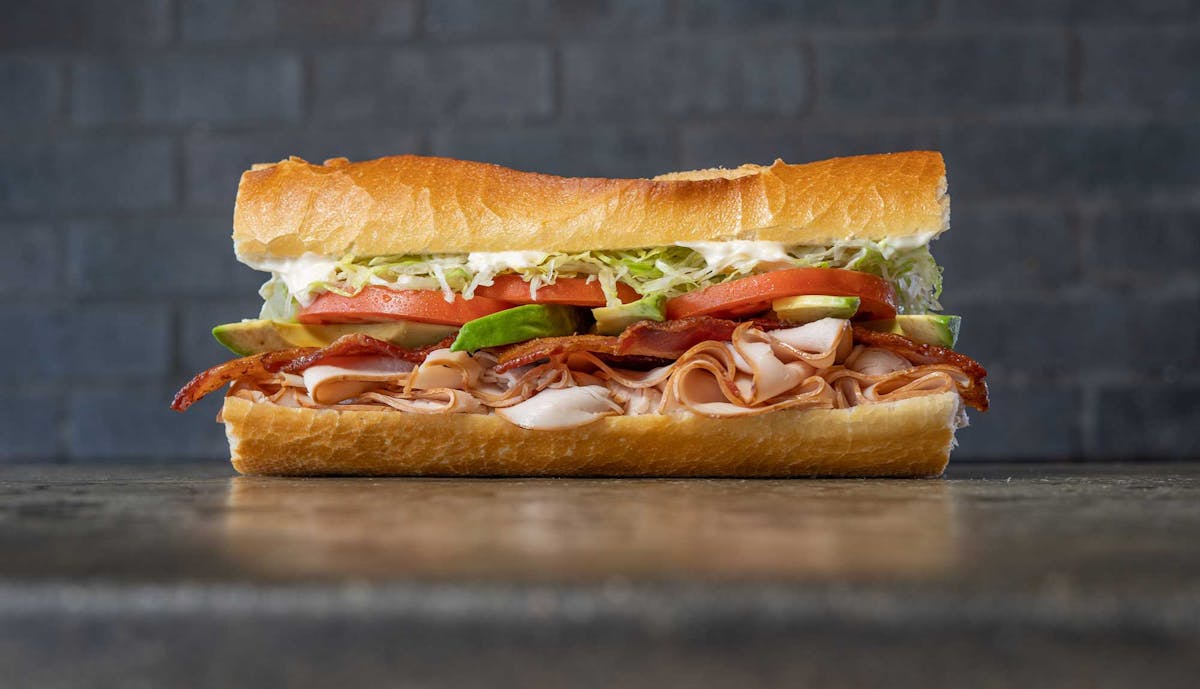 Fat Sal’s Terrific Turkey Club sandwich with sliced turkey, bacon, avocado, lettuce, tomato, and mayo on a hoagie roll
