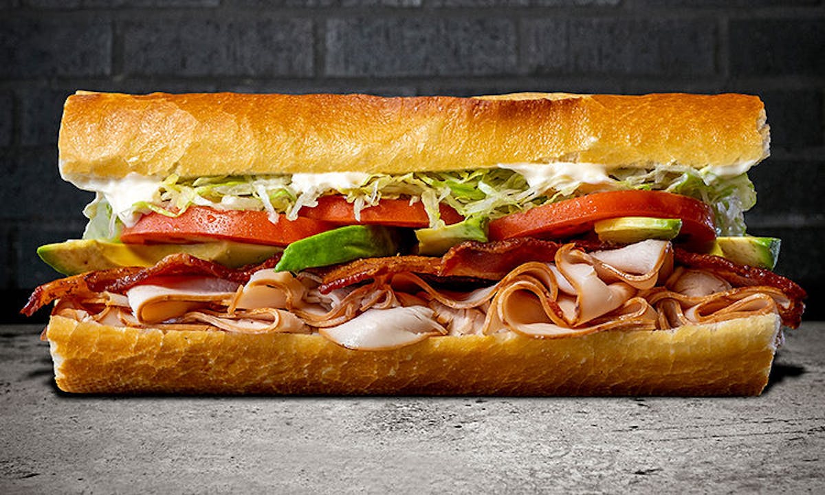 Fat Sal's turkey club sandwich on a toasted hoagie roll with bacon, avocado, turkey, lettuce, tomato, and mayo
