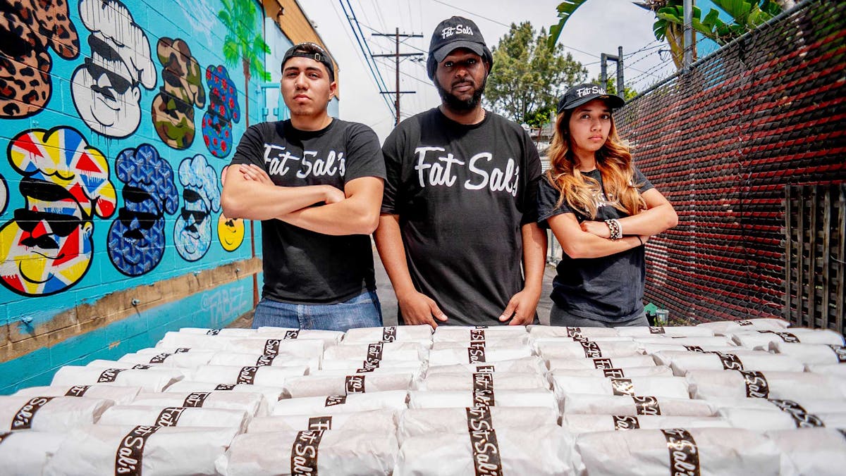 Fat Sal’s team standing behind a large catering order of wrapped sandwiches, ready for delivery in Los Angeles.