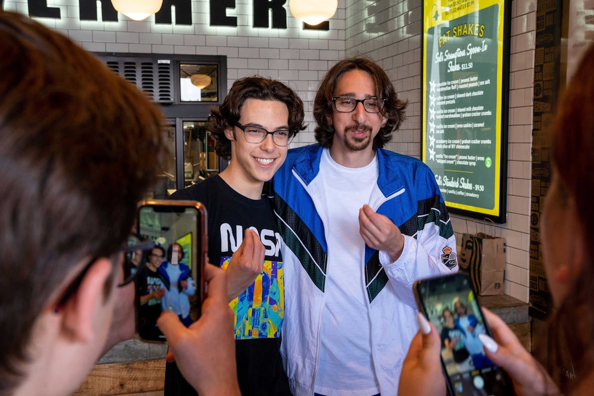 Influencer Cug posing with fans during a Fat Sal’s event in Los Angeles, with attendees taking photos inside the restaurant
