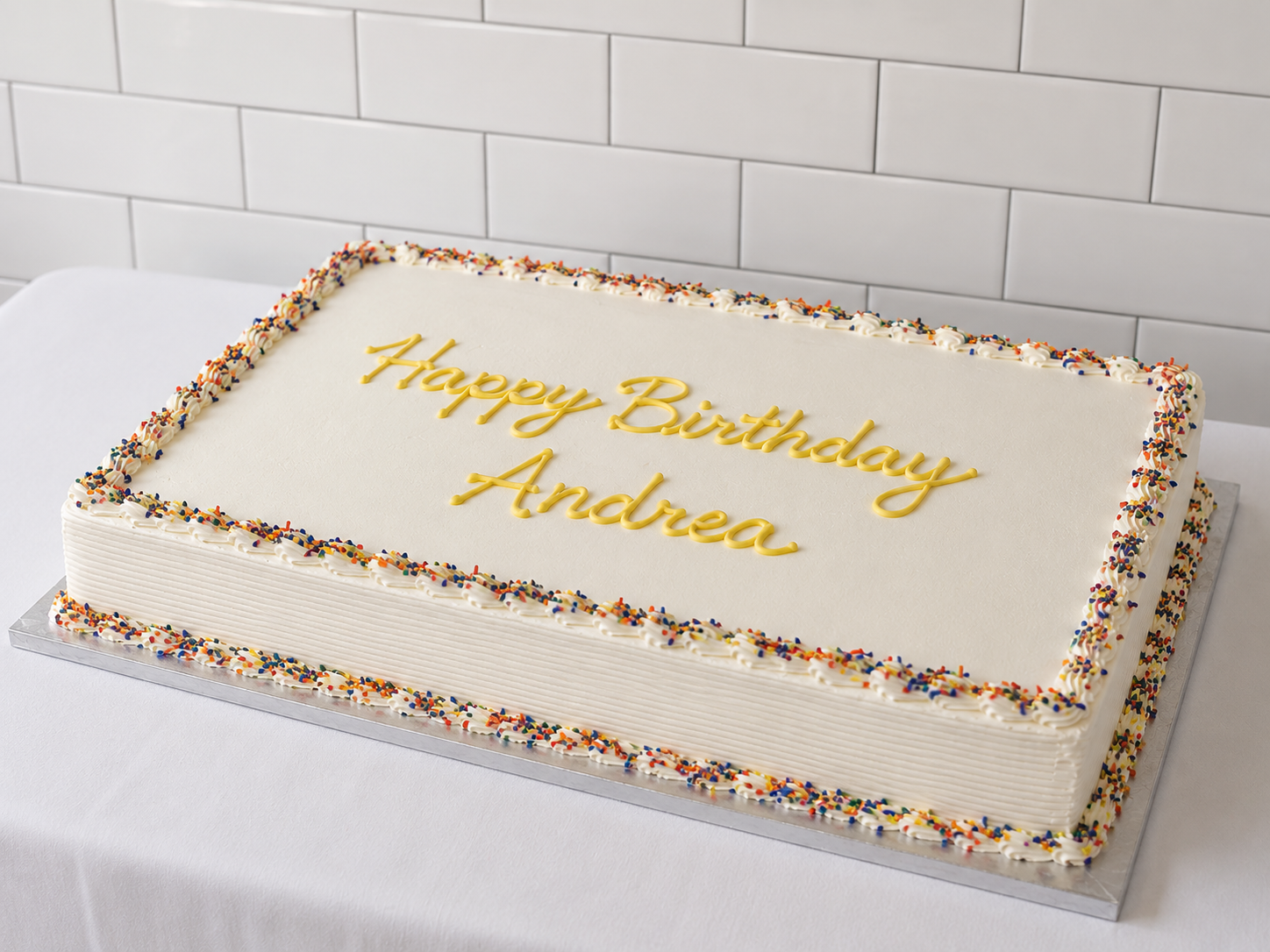 a white cake with yellow writing on it