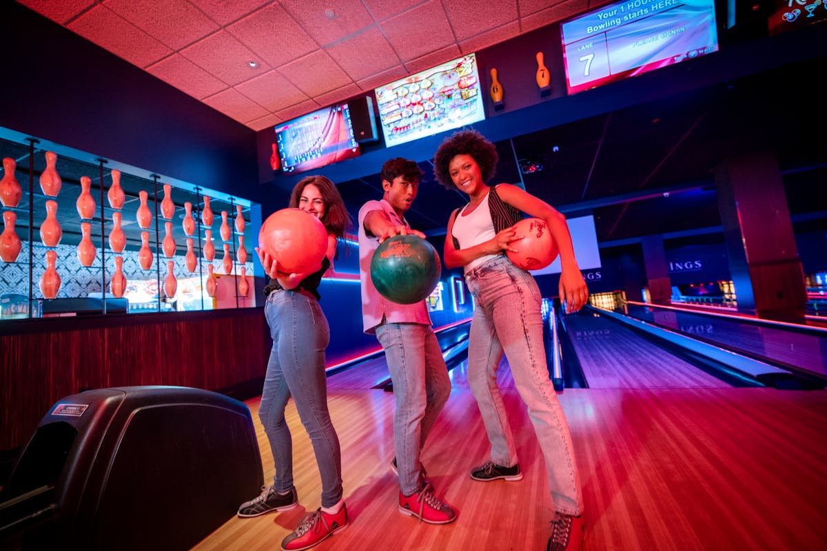 Three people bowling at Kings