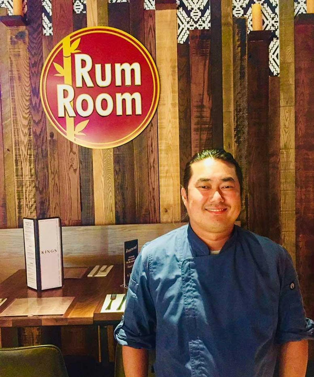 a man standing in front of a sign posing for the camera