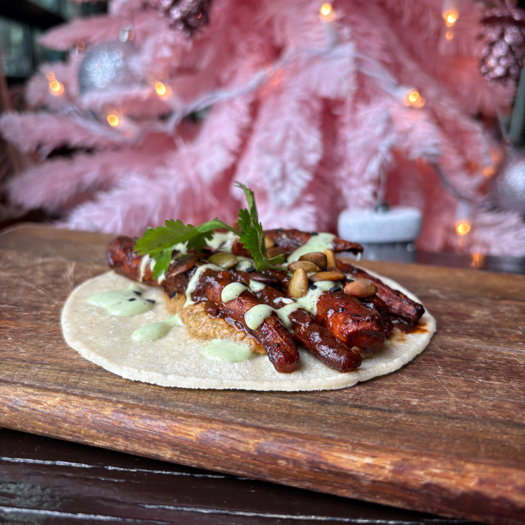 Carrot Mole Taco at Dos Santos with roasted carrots, mole sauce, sikil pak, cilantro crema, sesame seeds, and pepitas.