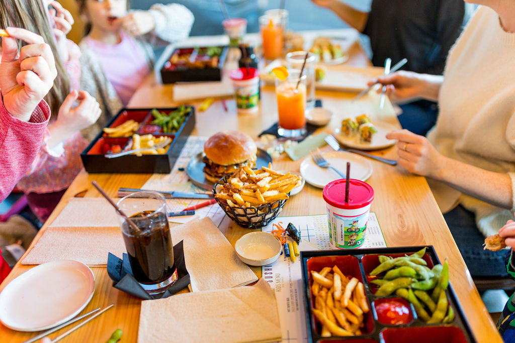 a group of people sitting at a table eating food
