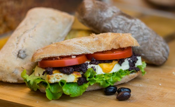 a close up of a sandwich sitting on top of a wooden table