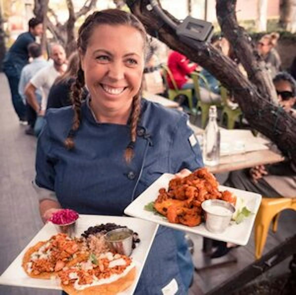 a woman standing in front of a plate of food