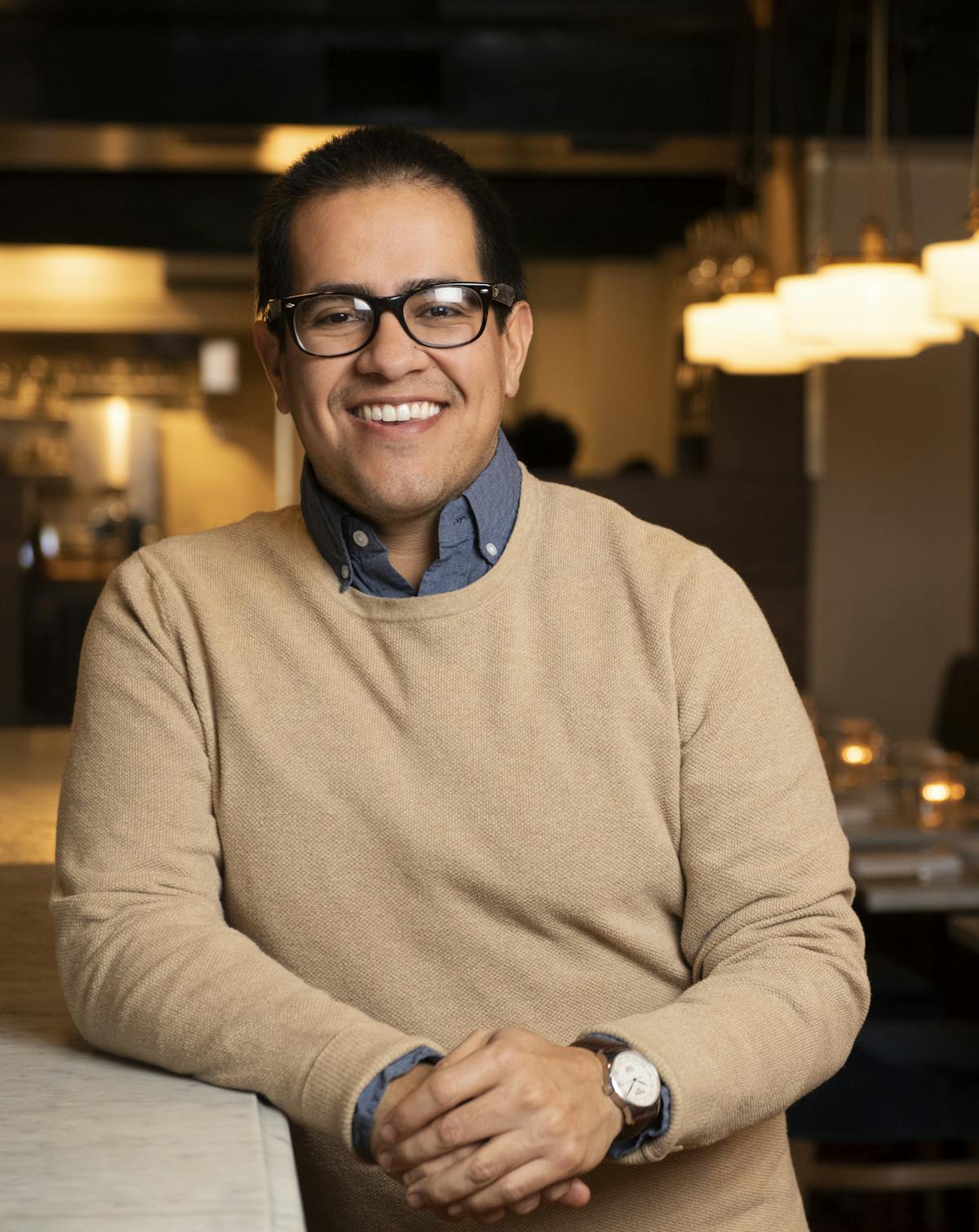 a man wearing glasses and smiling at the camera