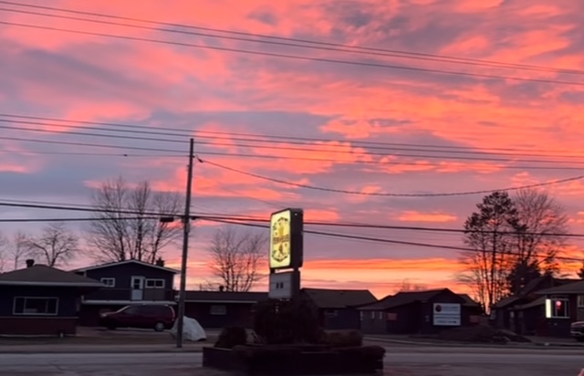 a train crossing a street at sunset