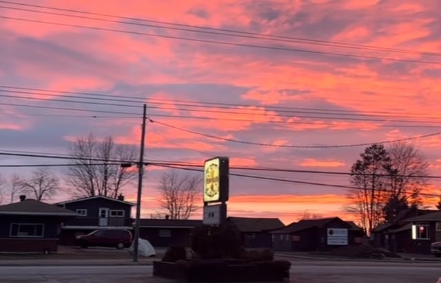 a train crossing a street at sunset