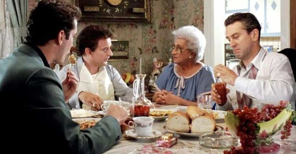 a group of people sitting at a table with food