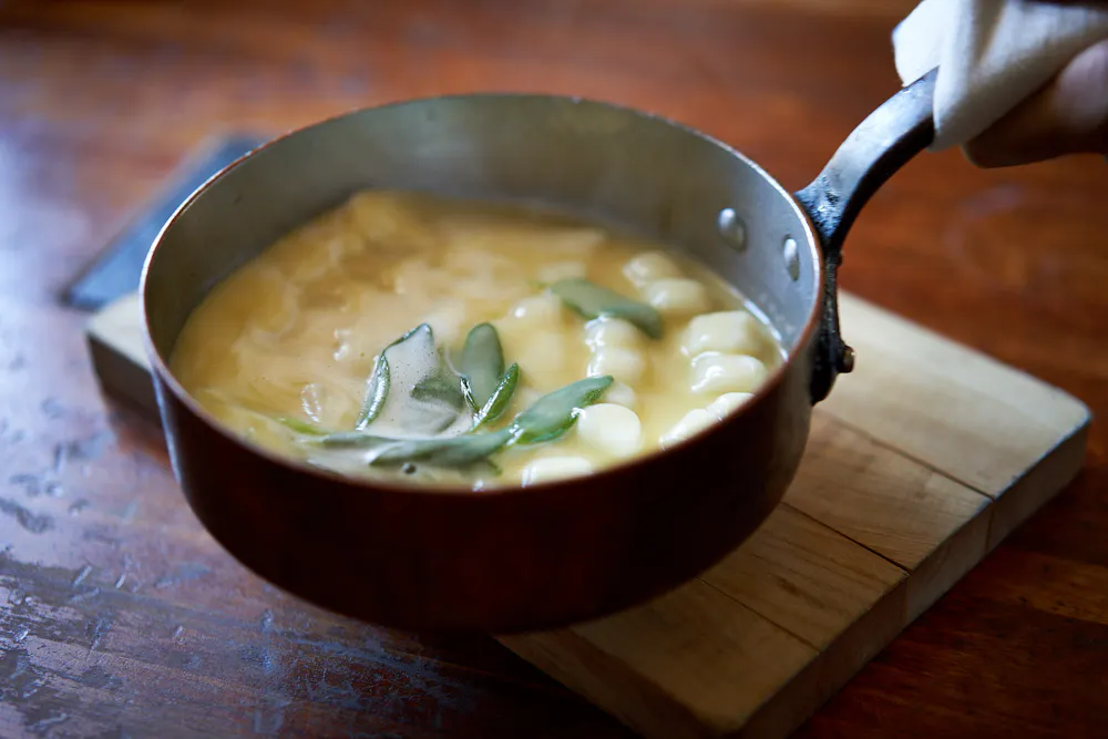 a bowl of soup sitting on top of a wooden table