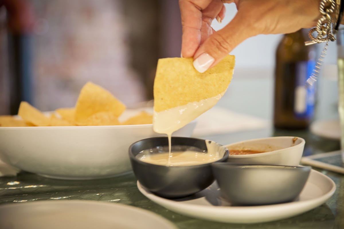 a person holding a plate of food on a table