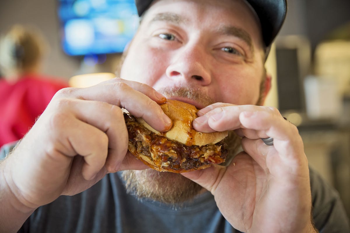 a close up of a person eating a slice of pizza