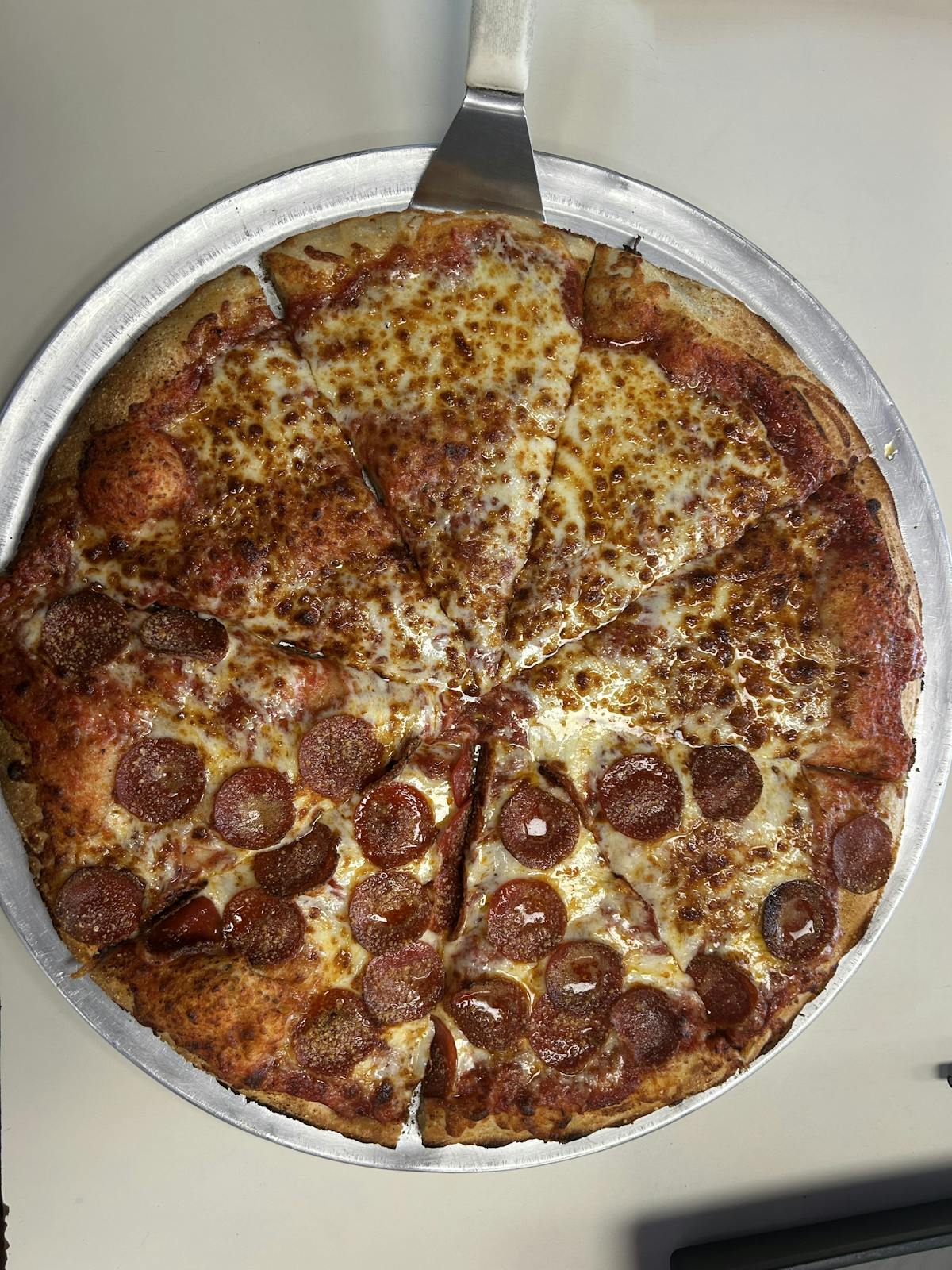 a pizza sitting on top of a pan on a table