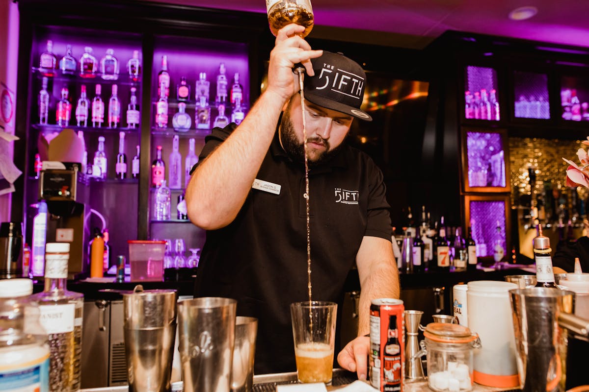 bartender pouring drinks into cup