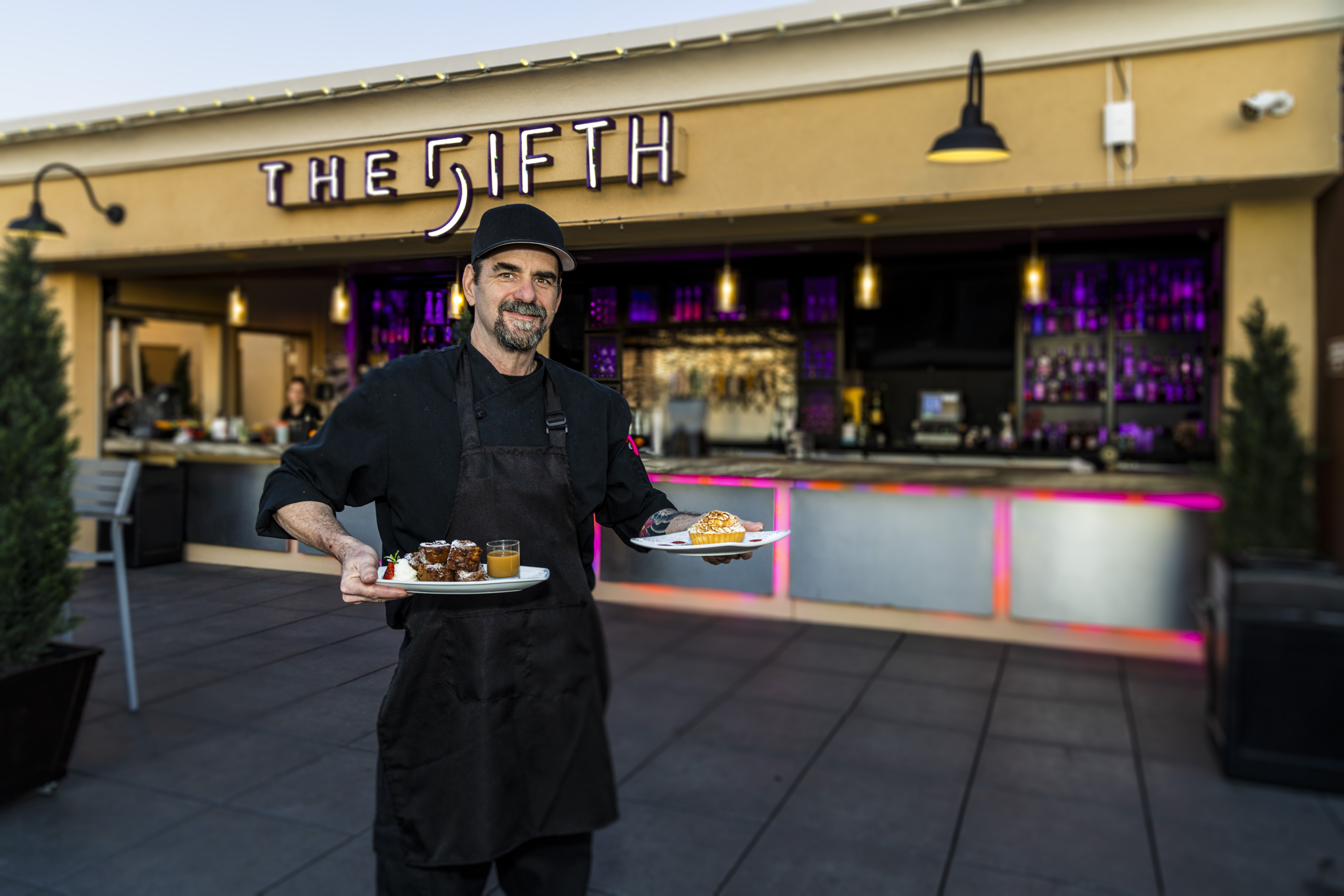 a man holding desserts for a photo
