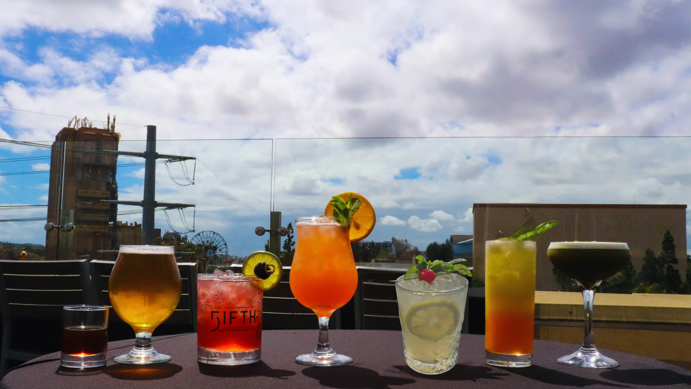 a group of cocktail drinks on a black linen table