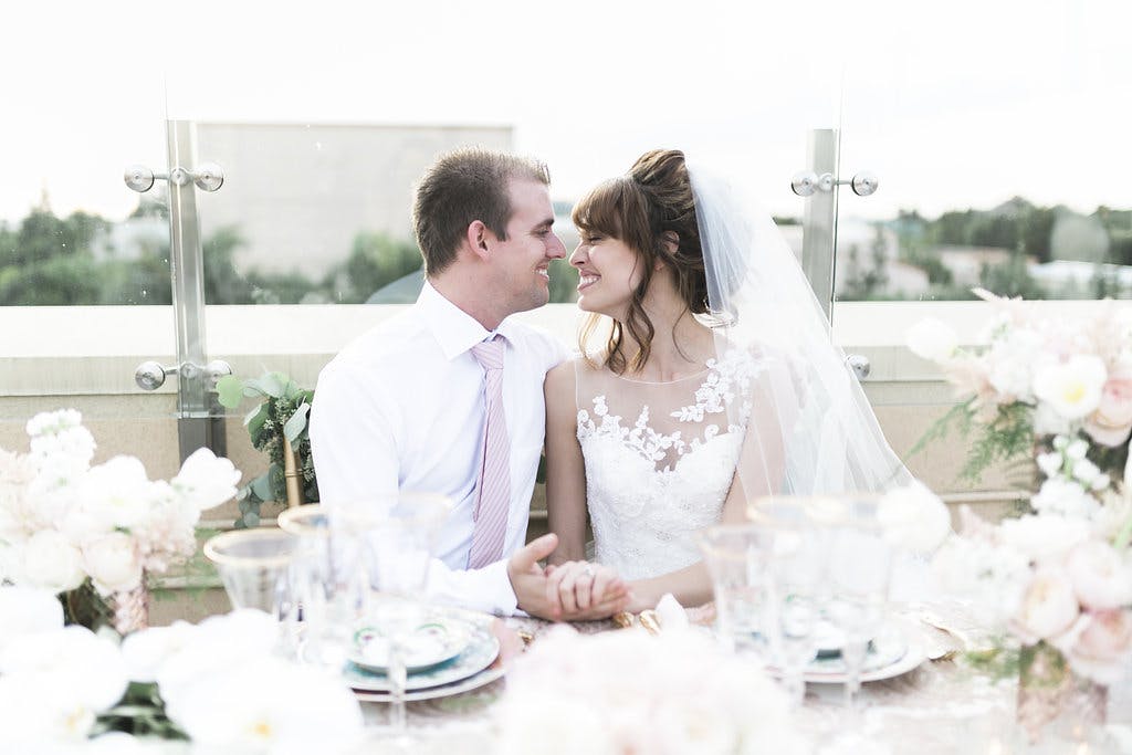a woman sitting at a table with wine glasses