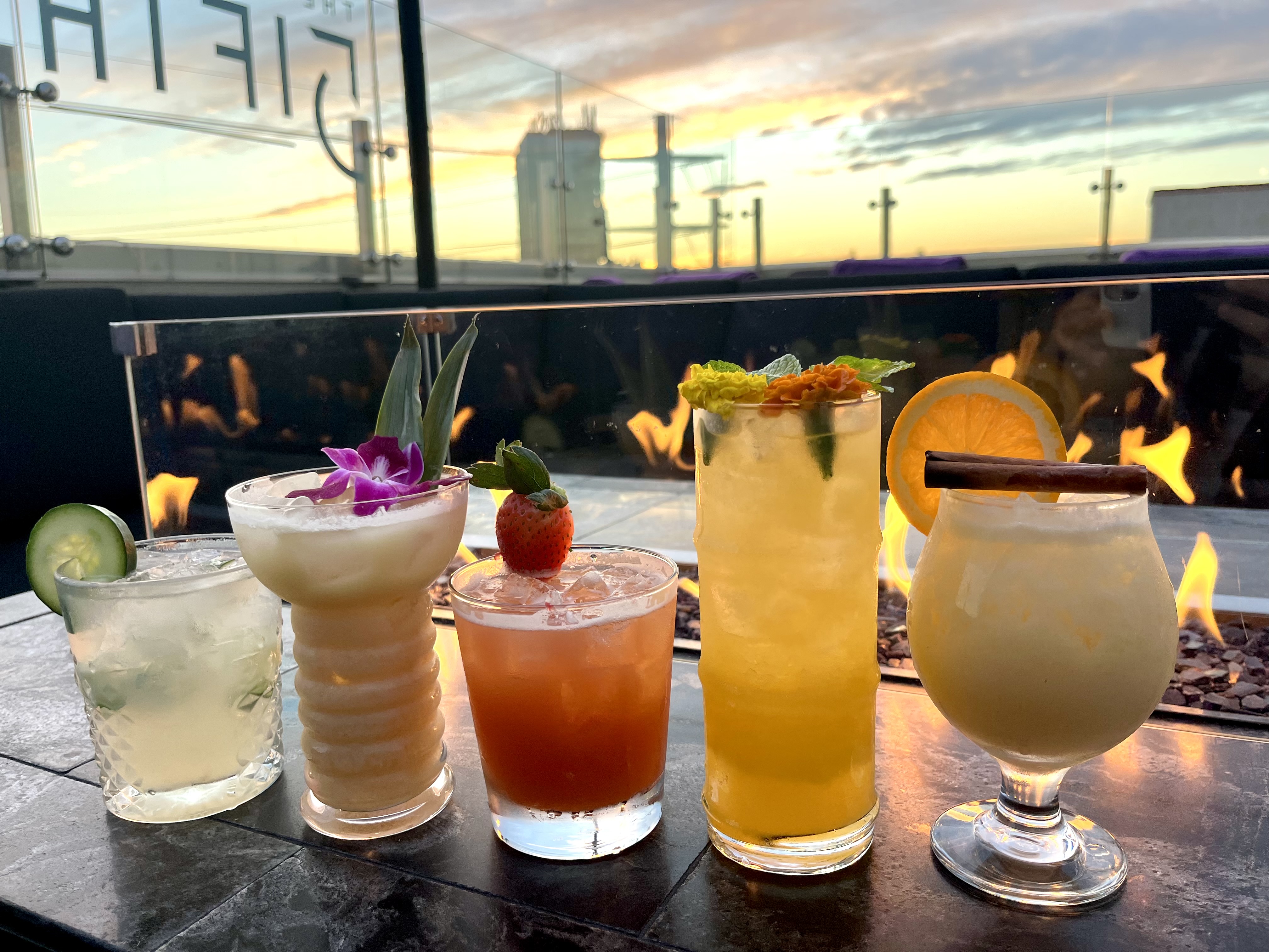 a group of cocktails in front of fire