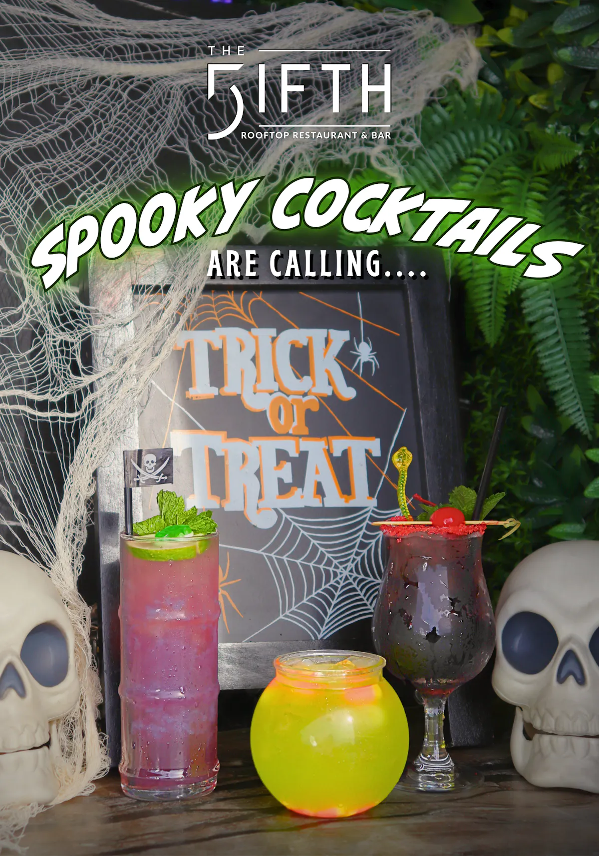 The Fifth Rooftop Restaurant & Bar Halloween spooky cocktails featuring colorful purple, green, and black drinks with skulls, spiderwebs, and Trick or Treat décor.