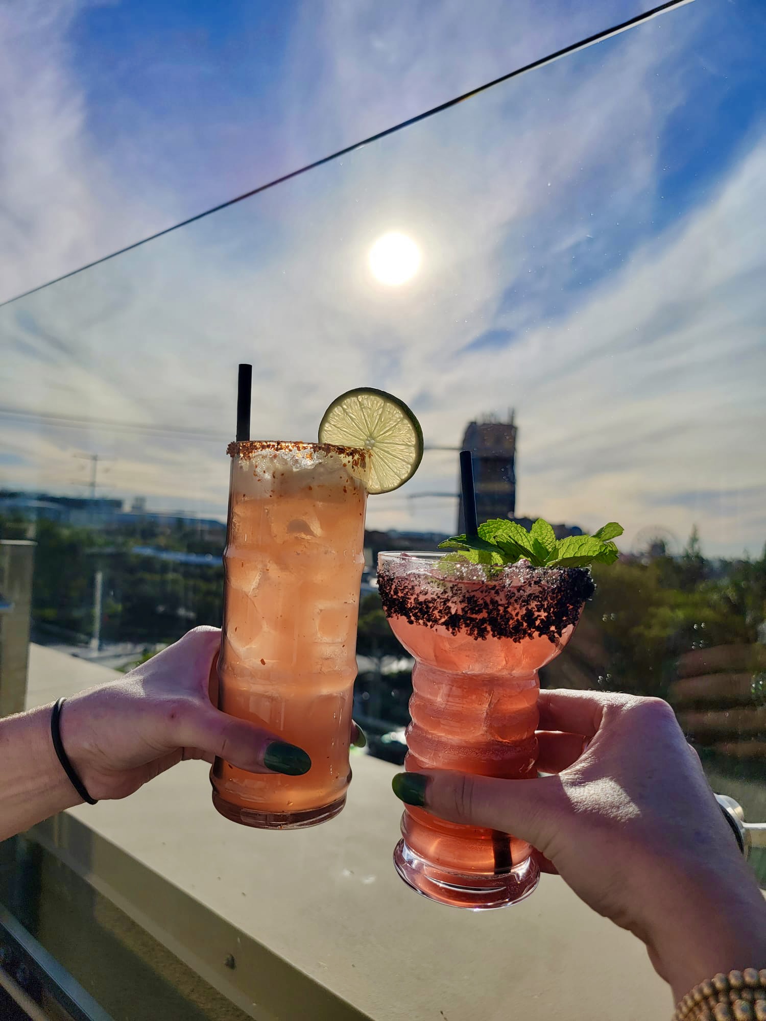 two hands holding cocktails