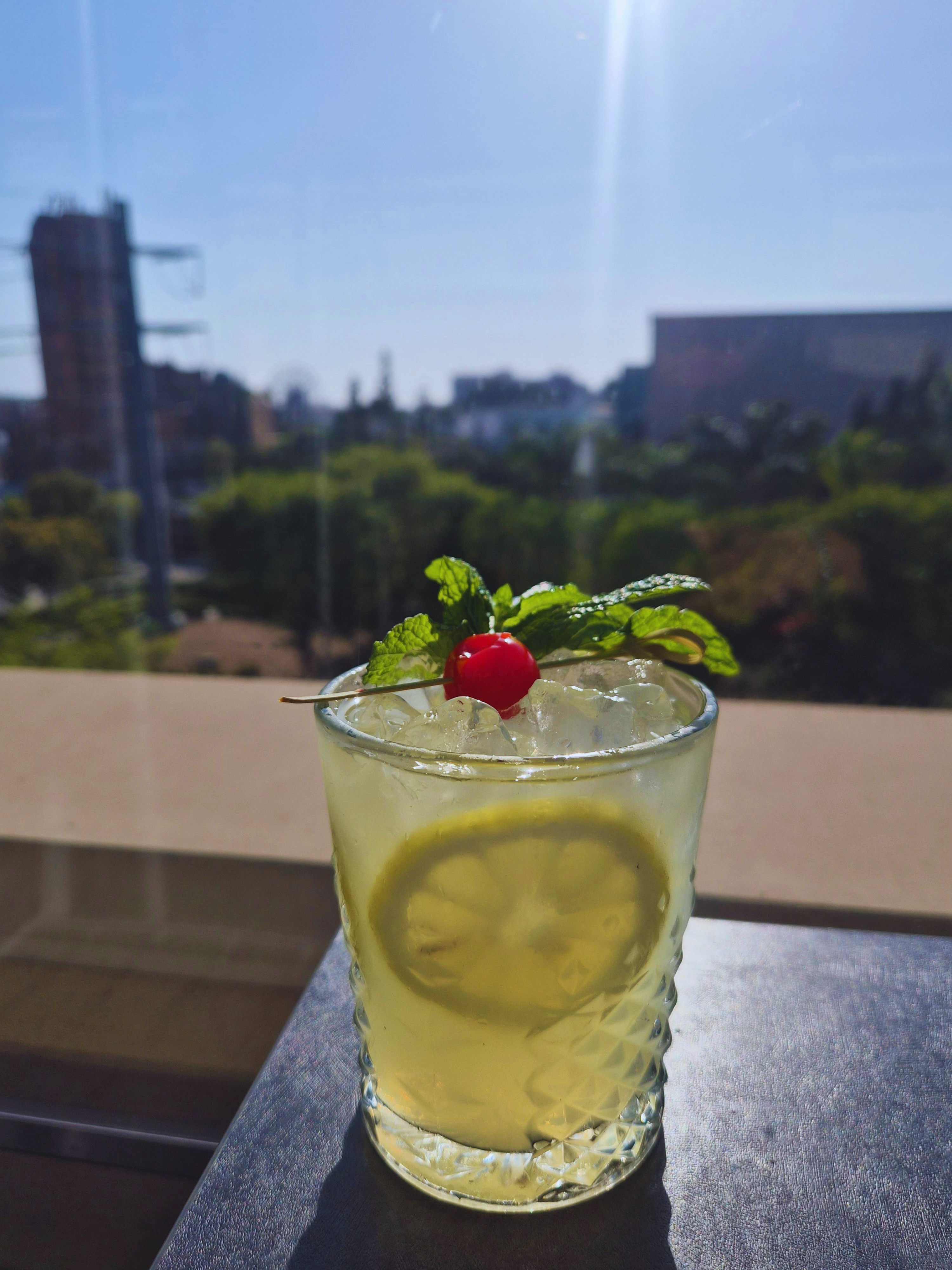 a peachy cocktail with a fruit, citrus, and leaf garnish