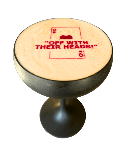 an orange cocktail with garnishes, a ring pop and lit candle fire torch