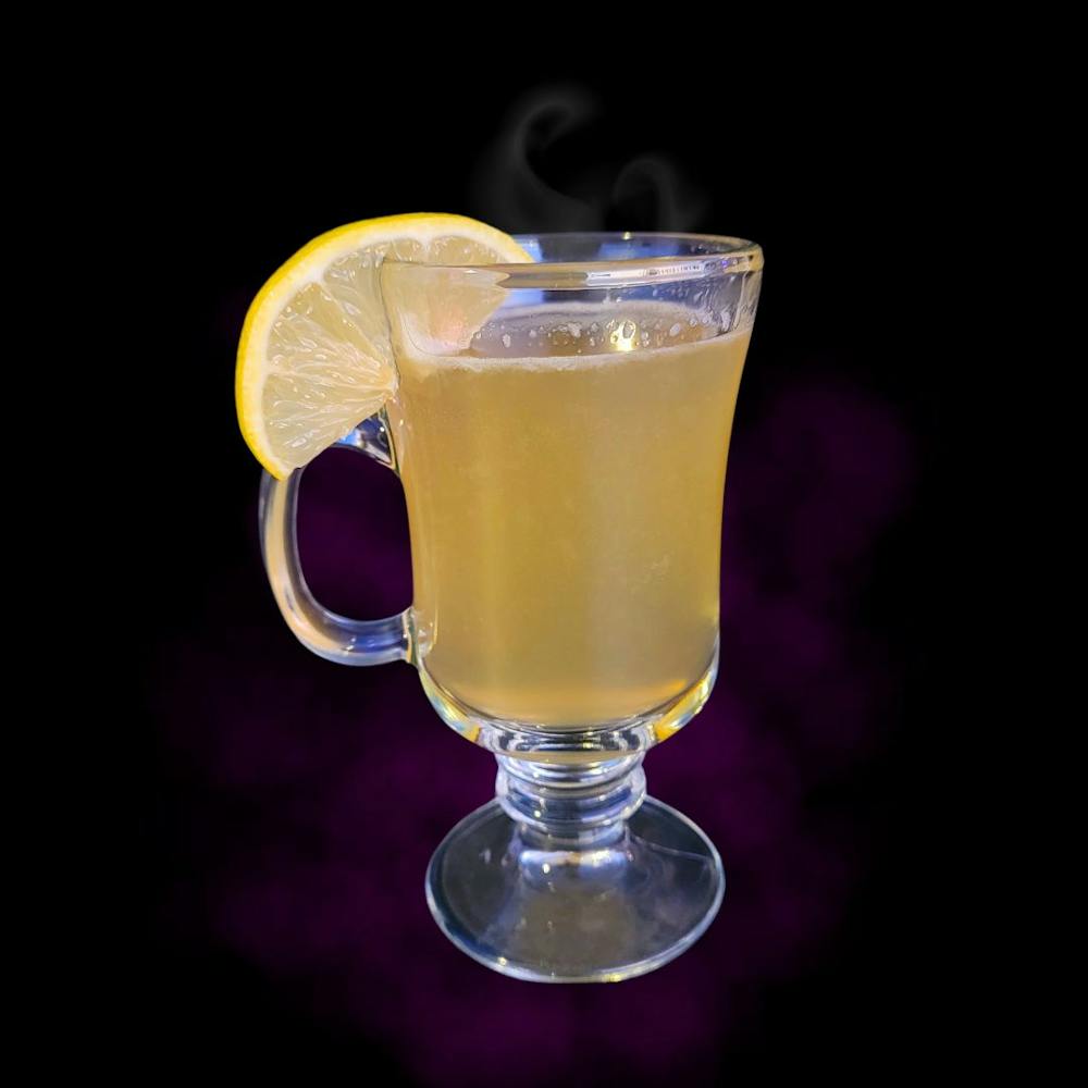 a glass of Hot Toddy with a lemon garnish and black background