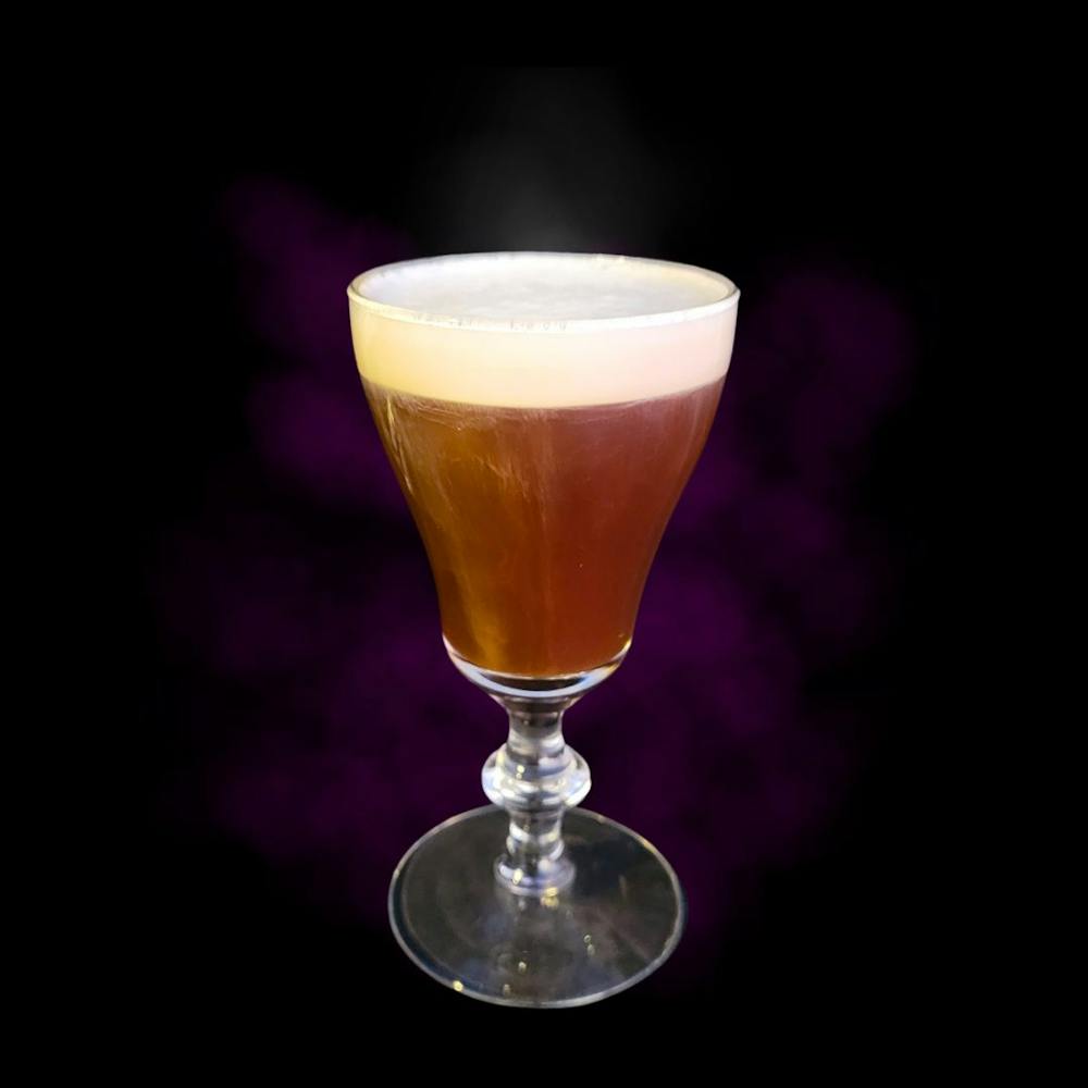 a glass of hot Irish Coffee with black background