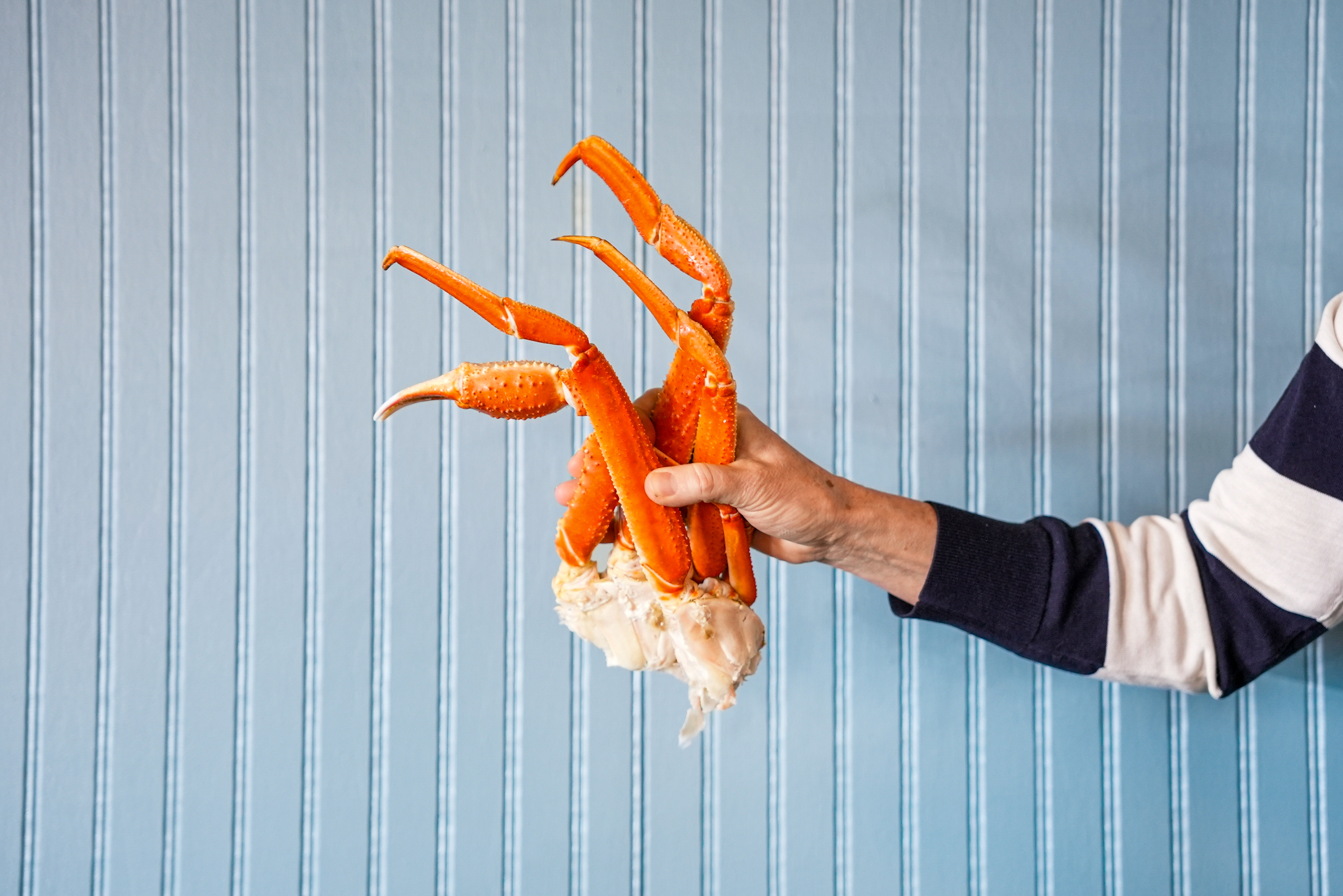 a person holding crab legs