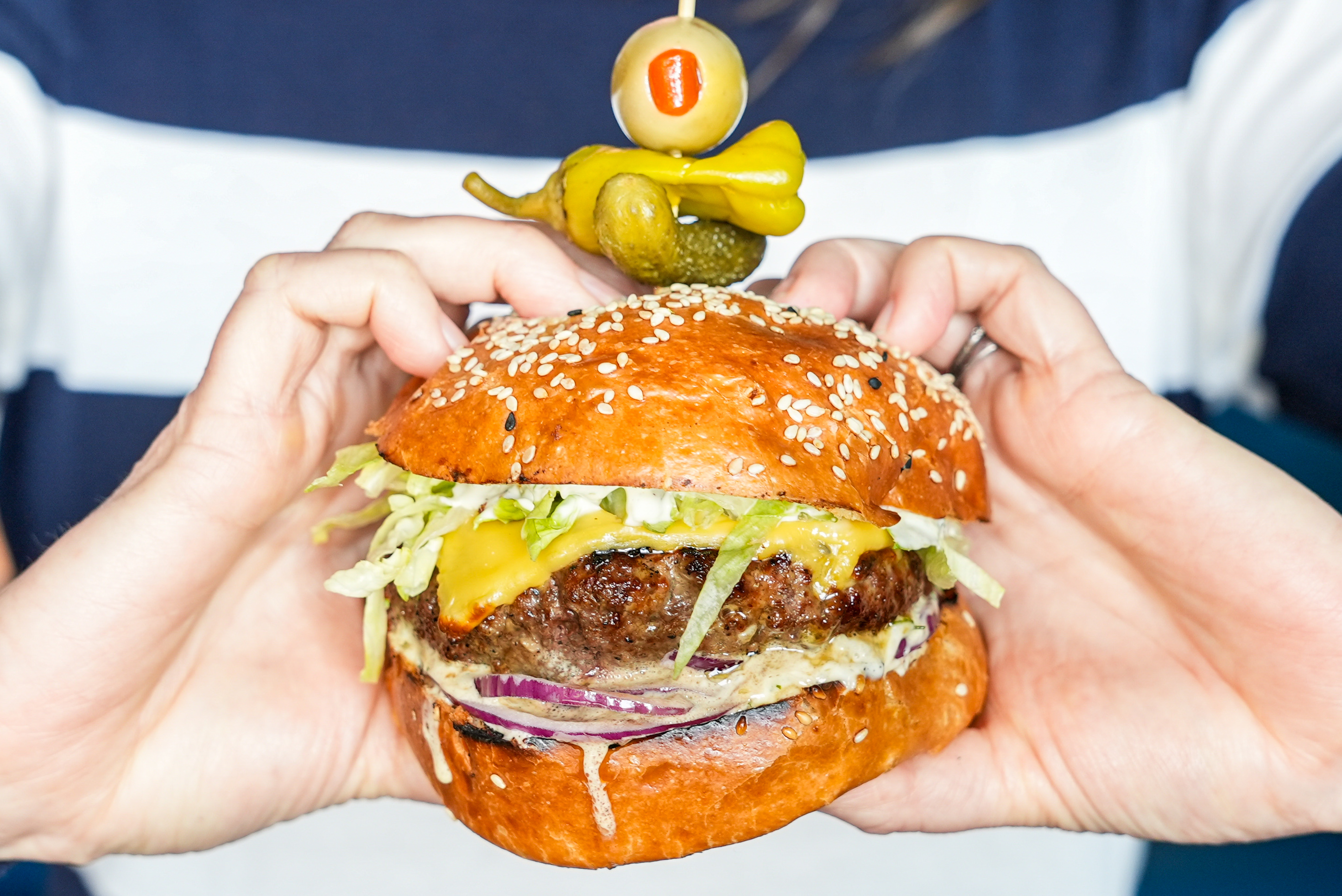 a person holding a burger