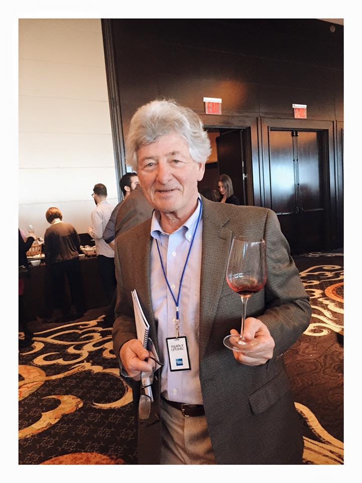 a man posing holding a wine glass