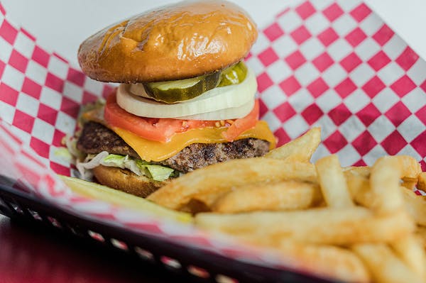 a close up of a sandwich and fries on a red tray