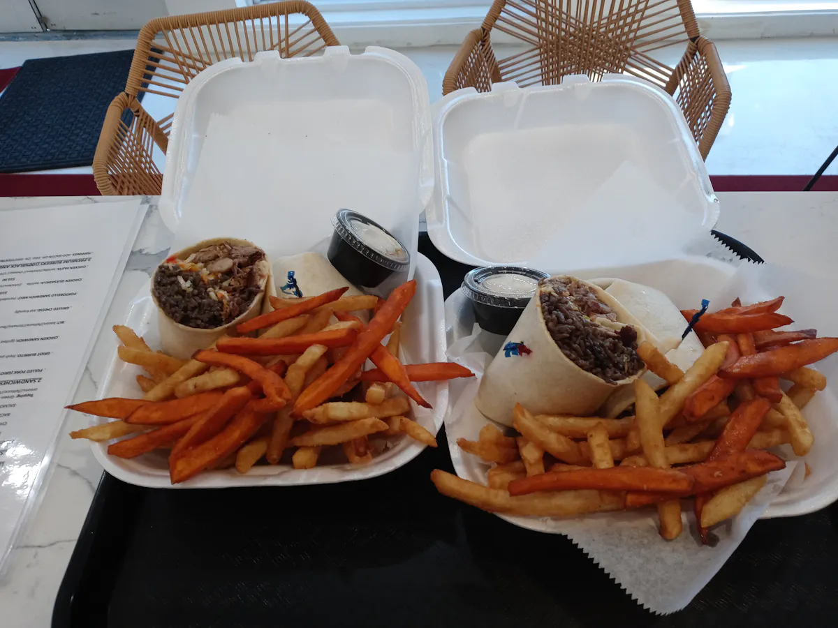 a plate of food with a sandwich and fries on a table
