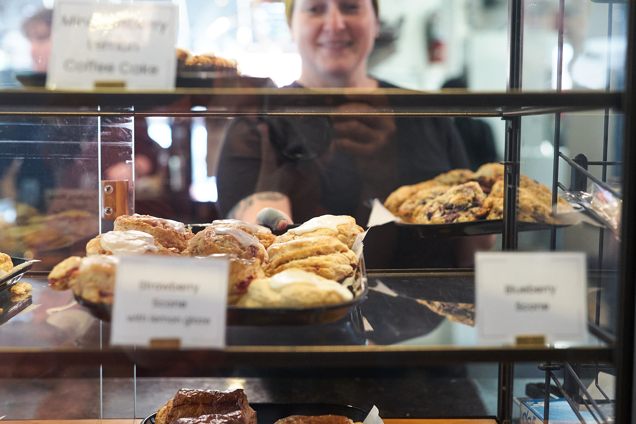 baker putting trays of pastries in case