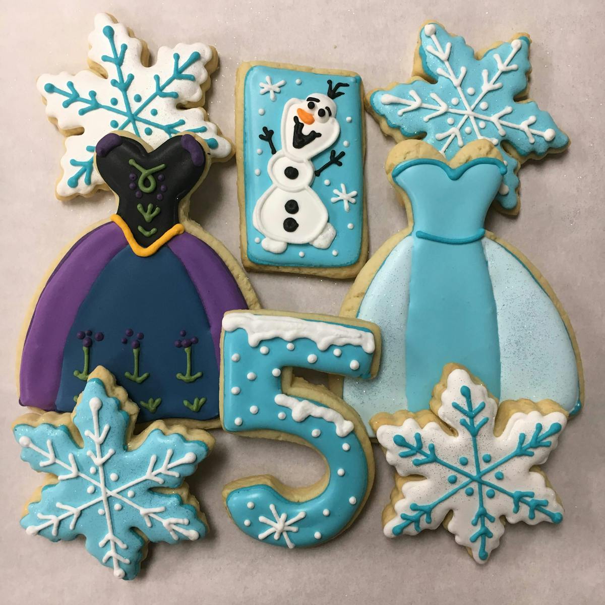 multiple decorated cookies sitting on a table