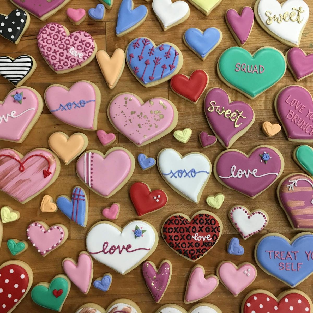multiple heart shaped cookies sitting on a wooden table