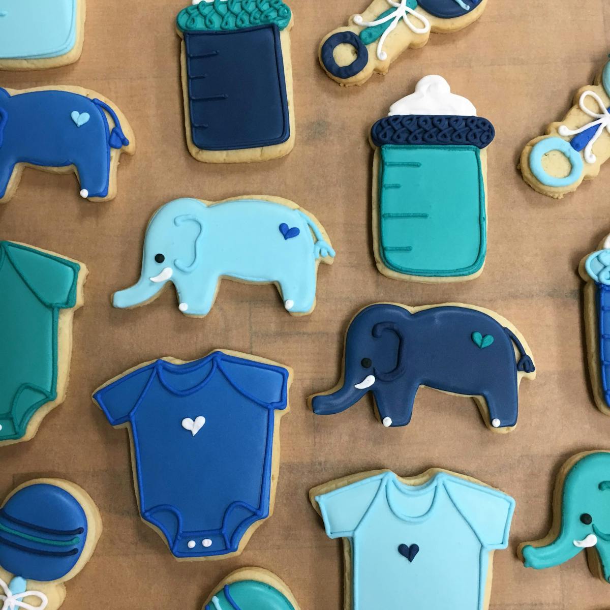 various shades of blue for bottles, onesies, elephants and rattles cookies