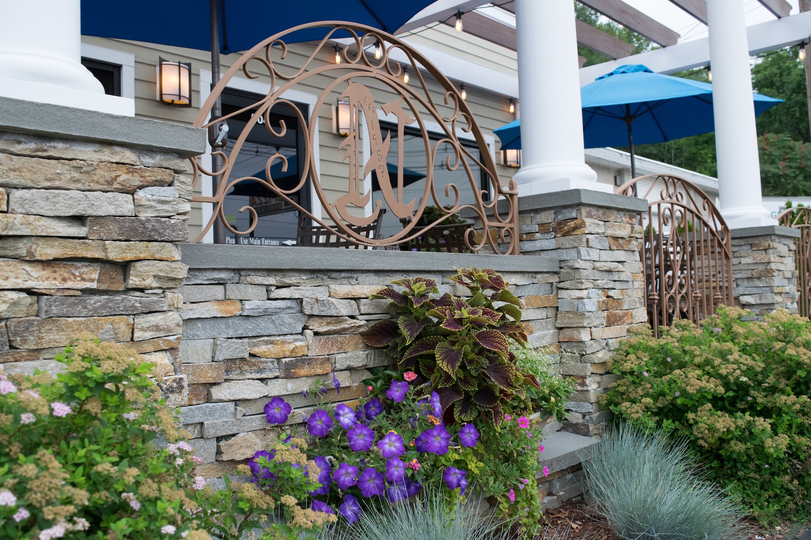 a close up of a flower garden in front of a brick building