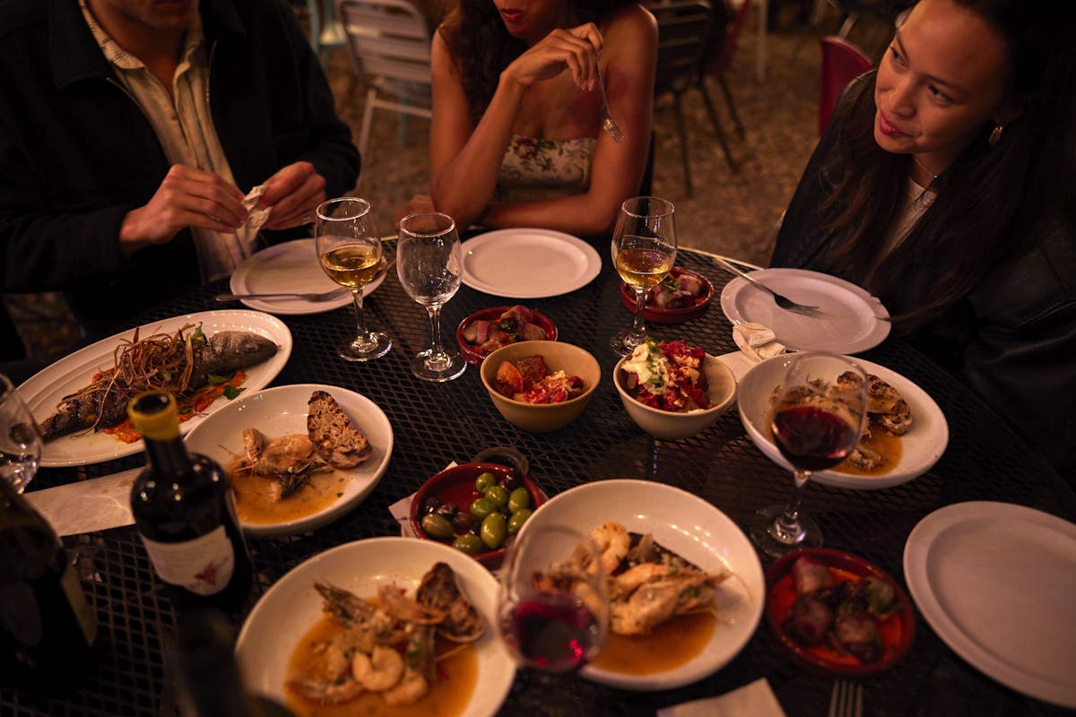 a group of people sitting at a table with a plate of food