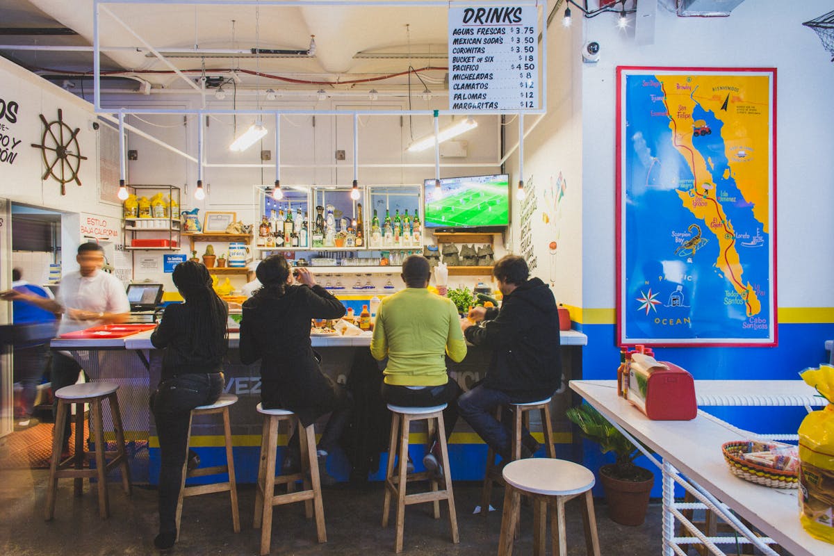 a group of people standing in front of a restaurant