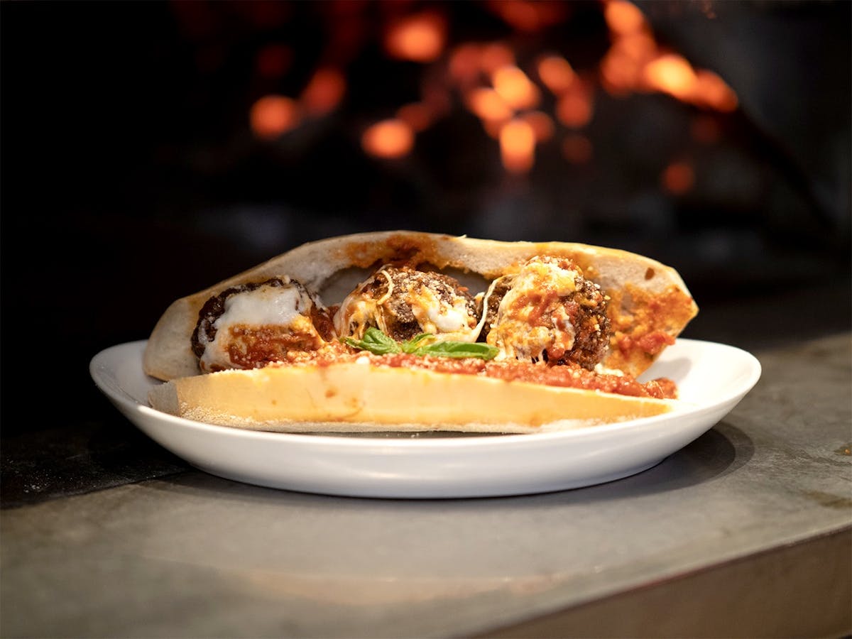 a meatball hero on plate on a table