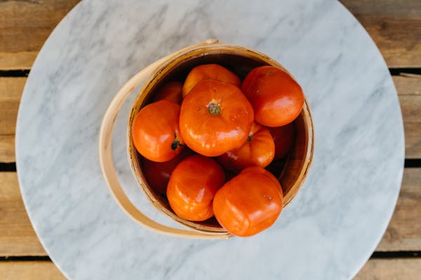 a bowl of oranges sitting on top of a wooden table